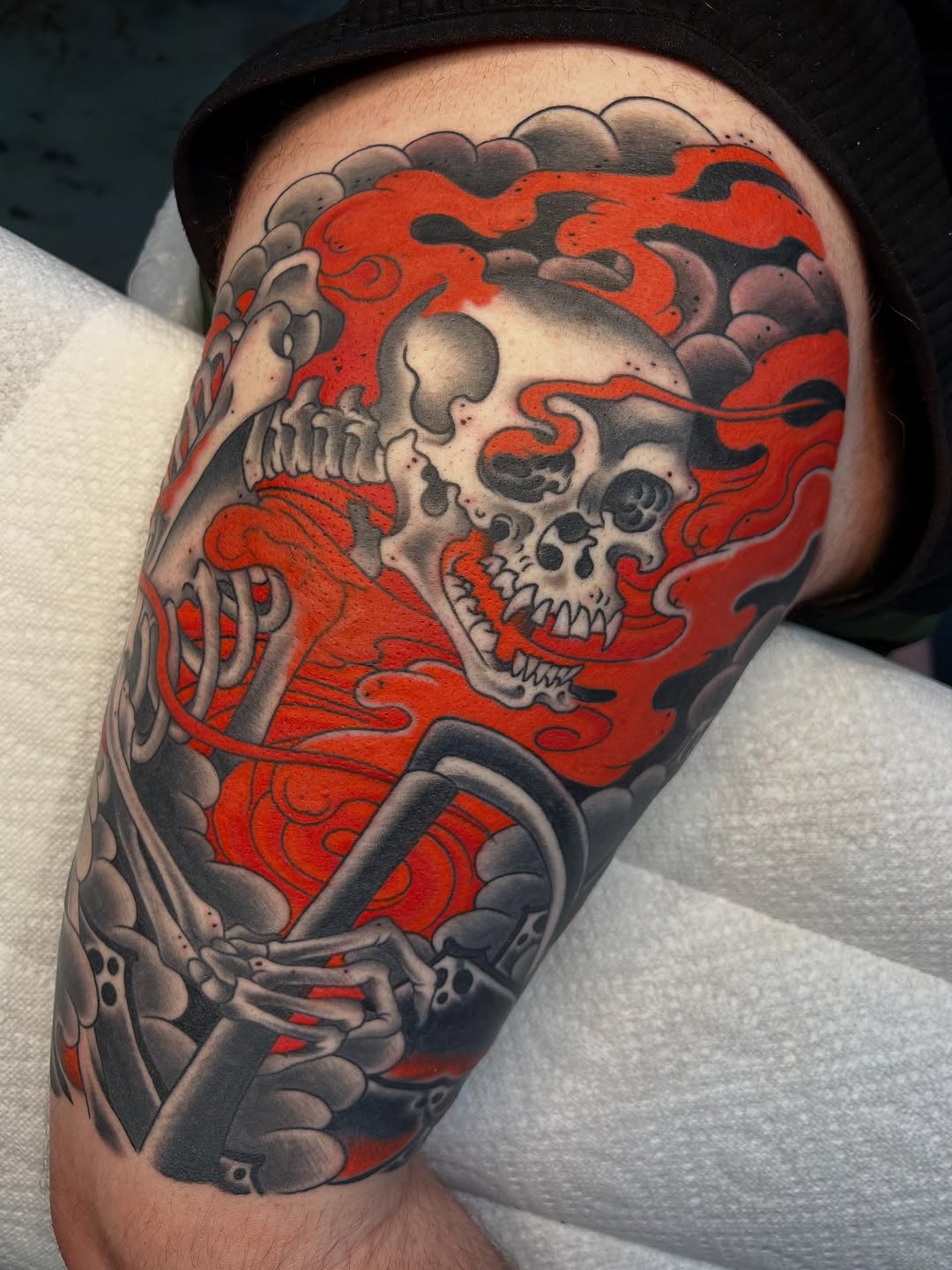 Neo-traditional skull with flames tattoo